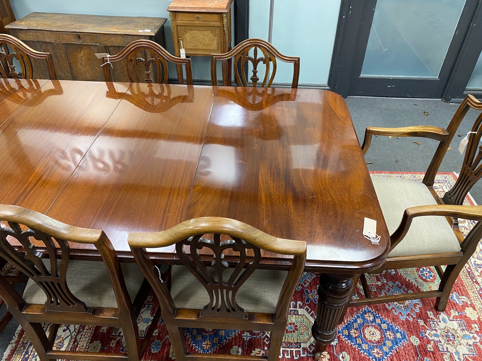 A late Victorian mahogany extending dining table, length 209cm extended with two spare leaves and winder, depth 106cm, height 76cm together with a set of eight Hepplewhite style dining chairs, two with arms